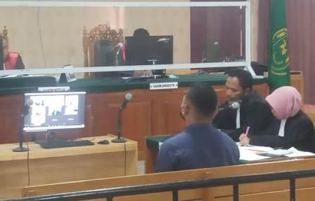 Tersangka kasus penganiayaan terhadap pemilik baliho, Geri Maries Bawoel, Pegawai Dishub Banjarmasin saat duduk di kursi pesakitan.(foto: dok koranbanjar.net)
